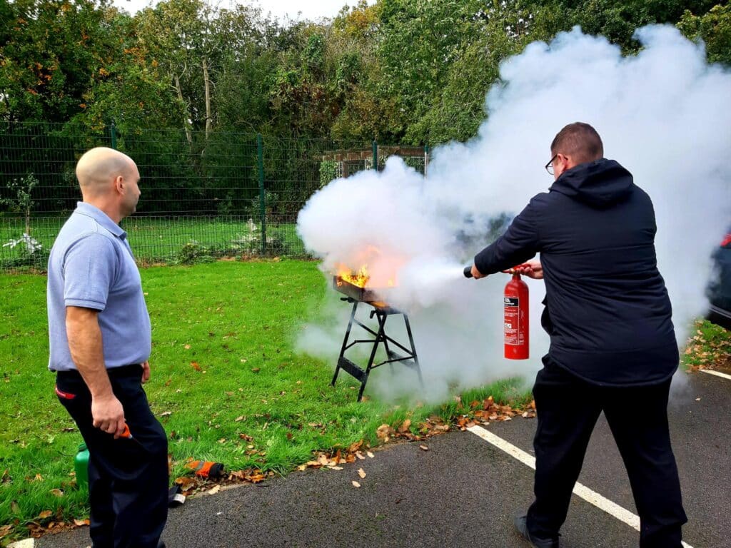 Paul with delegate, extinguishing a live fire with a co2 fire extinguisher in Derbyshire | PRT-Training